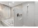 Stylish shower with glass and tiled surround, complemented by a tub and window at 2969 Talon Dr, Clearwater, FL 33761