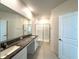Bright bathroom featuring double sinks, granite countertop, and glass-enclosed shower at 31745 Blue Passing Loop, Wesley Chapel, FL 33545
