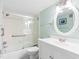 A well-lit bathroom features an oval mirror and a shower with sliding glass doors at 3210 Gulf Blvd # 108, Belleair Beach, FL 33786