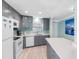Bright kitchen with updated appliances, gray cabinetry, and an island with seating at 3210 Gulf Blvd # 108, Belleair Beach, FL 33786