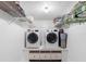 Convenient laundry room equipped with a side-by-side washer and dryer and ample shelving at 3210 Gulf Blvd # 108, Belleair Beach, FL 33786