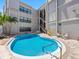 Outdoor pool with metal stairs, surrounded by multiple levels of condo balconies at 3210 Gulf Blvd # 108, Belleair Beach, FL 33786