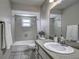 Well-lit bathroom features a shower-tub combo and a vanity with a large mirror at 3225 Bea Ct, Land O Lakes, FL 34639