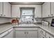 Bright kitchen featuring white cabinetry, countertops, and sink, creating a clean and functional cooking space at 3225 Bea Ct, Land O Lakes, FL 34639