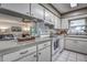 Clean kitchen featuring white appliances, cabinets, and a view into the living room, perfect for modern living at 3225 Bea Ct, Land O Lakes, FL 34639