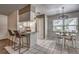 Stylish eat-in kitchen with bar seating and a view to a dining area with pendant lighting and large window at 3225 Bea Ct, Land O Lakes, FL 34639