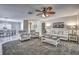 Inviting living room with a cozy sofa, striped armchairs, and a decorative ceiling fan at 3225 Bea Ct, Land O Lakes, FL 34639