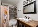 Nicely updated bathroom featuring a modern vanity and gray wood look tile shower surround at 3226 Palmetto Rd, Wimauma, FL 33598