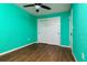 Bright bedroom features wood flooring, ceiling fan, and a closet with white bi-fold doors at 3226 Palmetto Rd, Wimauma, FL 33598