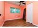 A bright bedroom with wood flooring, a ceiling fan, closet, and natural light from the exterior window at 3226 Palmetto Rd, Wimauma, FL 33598