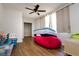Bedroom with wood floors, ceiling fan, closet, and a large window providing lots of natural light at 3226 Palmetto Rd, Wimauma, FL 33598