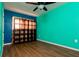 This bedroom offers ample storage with a large, dark wooden bookcase complemented by wood flooring at 3226 Palmetto Rd, Wimauma, FL 33598
