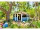 Exterior view of a dilapidated blue gazebo surrounded by overgrowth and debris on a sunny day at 3226 Palmetto Rd, Wimauma, FL 33598