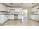 Bright, tiled kitchen with modern white cabinetry, black hardware, and views into the adjacent living area at 3226 Palmetto Rd, Wimauma, FL 33598