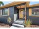 Close-up of home with gray exterior, yellow door and shutters, and wood porch at 3228 7Th N Ave, St Petersburg, FL 33713
