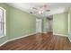 Large bedroom featuring wood floors, green walls, and natural lighting from windows at 34193 Carpenter Cir, Webster, FL 33597