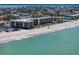 Aerial view of a beachfront condo complex with access to a sandy beach and clear blue ocean waters at 3500 Gulf Blvd # 314, Belleair Beach, FL 33786