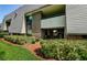 Condo exterior featuring brick accents, balcony, manicured shrubs and green lawn at 36750 Us 19 N # 5-111, Palm Harbor, FL 34684