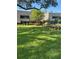 Exterior view of a well-maintained two-story building with lush green lawn and beautiful landscaping at 36750 Us 19 N # 5-111, Palm Harbor, FL 34684