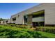 Exterior view of condo building with manicured shrubs and green lawn at 36750 Us 19 N # 5-111, Palm Harbor, FL 34684