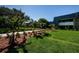 Exterior shot of the building on a sunny day showing lawn, mature trees, and tropical landscaping at 36750 Us 19 N # 5-111, Palm Harbor, FL 34684