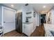 Galley kitchen with stainless steel refrigerator, white cabinets, granite countertops and tile backsplash at 36750 Us 19 N # 5-111, Palm Harbor, FL 34684