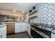 Updated kitchen featuring stainless steel oven and dishwasher, granite countertops and decorative backsplash at 36750 Us 19 N # 5-111, Palm Harbor, FL 34684