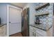 Efficient kitchen area featuring stainless steel fridge, granite counters, white cabinets, and decorative backsplash at 36750 Us 19 N # 5-111, Palm Harbor, FL 34684