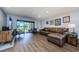 Living room with modern furnishings, wood floors, and a sliding glass door to the exterior at 36750 Us 19 N # 5-111, Palm Harbor, FL 34684