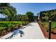 Long sidewalk leading up to the building entrance with lush plants and trees lining each side at 36750 Us 19 N # 5-111, Palm Harbor, FL 34684