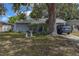 Quaint house with mature trees, a front yard, and a driveway with a parked car at 3721 140Th Ave, Largo, FL 33771