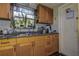 Functional kitchen features wooden cabinets, a stainless steel sink, and natural light from a window at 3721 140Th Ave, Largo, FL 33771