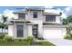 Modern two-story home featuring stone accents, a two-car garage, and tropical landscaping at 3816 109Th Street East, Palmetto, FL 34221