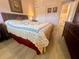 Comfortable bedroom with a decorative bedspread, wooden furniture, and view to bathroom at 4001 58Th N St # 18, Kenneth City, FL 33709