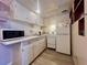Galley kitchen with white cabinets and appliances, complemented by light wood-look floors at 4001 58Th N St # 18, Kenneth City, FL 33709