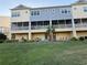 Backyard view of townhomes featuring screened lanais, green lawn and tropical landscaping at 4053 Rocky Shores Dr, Tampa, FL 33634