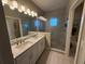 Bright bathroom featuring double sinks, granite countertop and modern, glass-enclosed shower at 4053 Rocky Shores Dr, Tampa, FL 33634