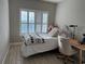 Well-lit bedroom featuring a comfortable bed, a neutral color palette, and wood-look flooring at 4053 Rocky Shores Dr, Tampa, FL 33634