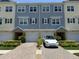 A well-maintained townhome featuring a brick driveway, attached garages, and manicured landscaping at 4053 Rocky Shores Dr, Tampa, FL 33634