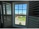 Window view with plantation shutters, offering a neighborhood view of green lawns, palm trees and beautiful homes at 4053 Rocky Shores Dr, Tampa, FL 33634