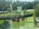 Screened window view of lush green lawn, shrubbery, mature trees and a peaceful lake with blue water at 4053 Rocky Shores Dr, Tampa, FL 33634
