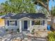 Attractive single-story home boasts a gray exterior, dark blue door, and manicured landscaping at 419 40Th S Ave, St Petersburg, FL 33705