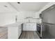 Bright kitchen features white cabinetry, quartz countertops, stainless appliances, and laminate flooring at 419 40Th S Ave, St Petersburg, FL 33705