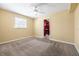 Bedroom featuring neutral carpet, a ceiling fan, and a view into the walk-in closet at 4732 W Wyoming Ave, Tampa, FL 33616