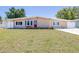 Charming single-story home features a well-manicured lawn and a vibrant red front door at 4732 W Wyoming Ave, Tampa, FL 33616
