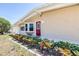 Close-up of a home's entry featuring a red door, well-maintained landscaping, and clear house numbers at 4732 W Wyoming Ave, Tampa, FL 33616