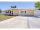 Well-maintained single-story home with a brick facade, manicured lawn and long driveway at 4732 W Wyoming Ave, Tampa, FL 33616