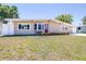 Charming single-story home featuring a well-kept lawn and an inviting red front door at 4732 W Wyoming Ave, Tampa, FL 33616
