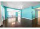 Bright living room with hardwood floors, and a white ceiling fan, and lots of natural light from large windows at 4732 W Wyoming Ave, Tampa, FL 33616