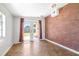 Bright sun room with access to backyard through glass doors, featuring eye-catching brick accent wall at 4732 W Wyoming Ave, Tampa, FL 33616